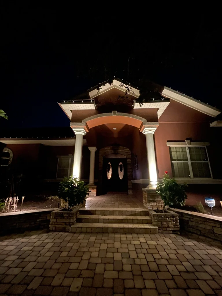 Outdoor wall lighting on Lake Nona residence's front columns, highlighting architectural elegance and improving safety by Southern Outdoor Lighting